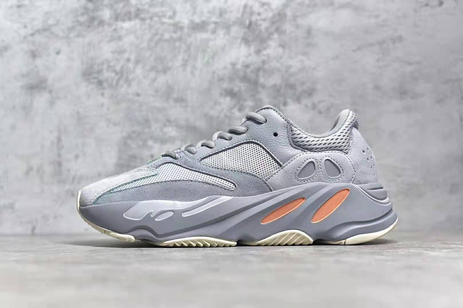 Yeezy Boost 700 “Inertia” 鞋款以灰色为主调，但每个部分都以不同的材质和不同深浅的灰色呈现，展现出丰富的层次感。中底以亮眼的浅橙色点缀，最后以沙色外底收尾，延续侃爷一贯偏爱的大地色主题 + 亮色点缀。相比前两款配色更加耐看百搭，也更